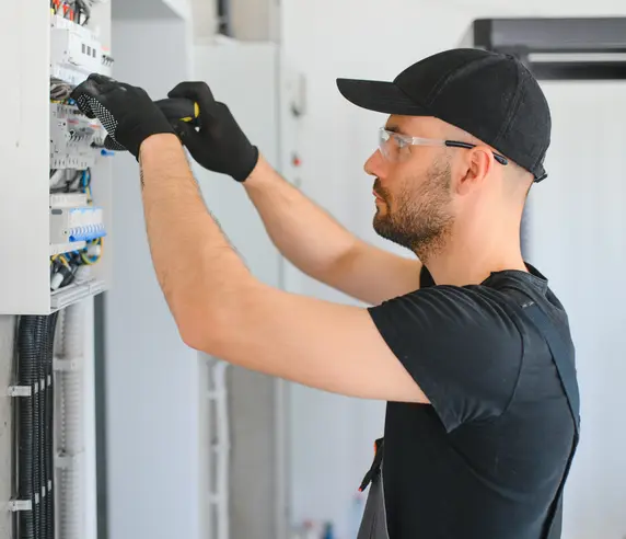 Un électricien au travail sur un tableau électrique